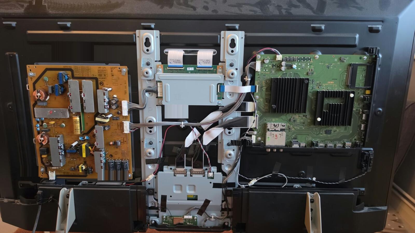 The back of a Sony Bravia KD-49XF9005 with the cover off, power board on the left and the BM2A main board on the right