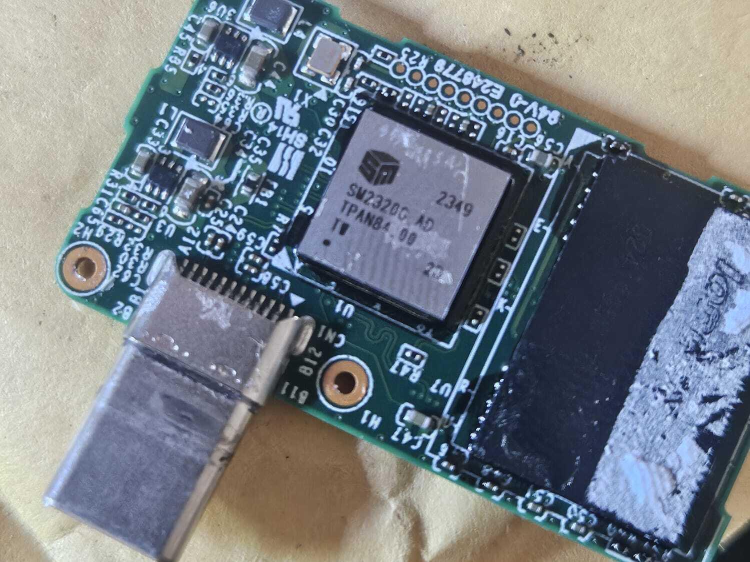 The Lexar Go SSD's circuit board out of its case, with the bent USB-C plug still attached at the board edge