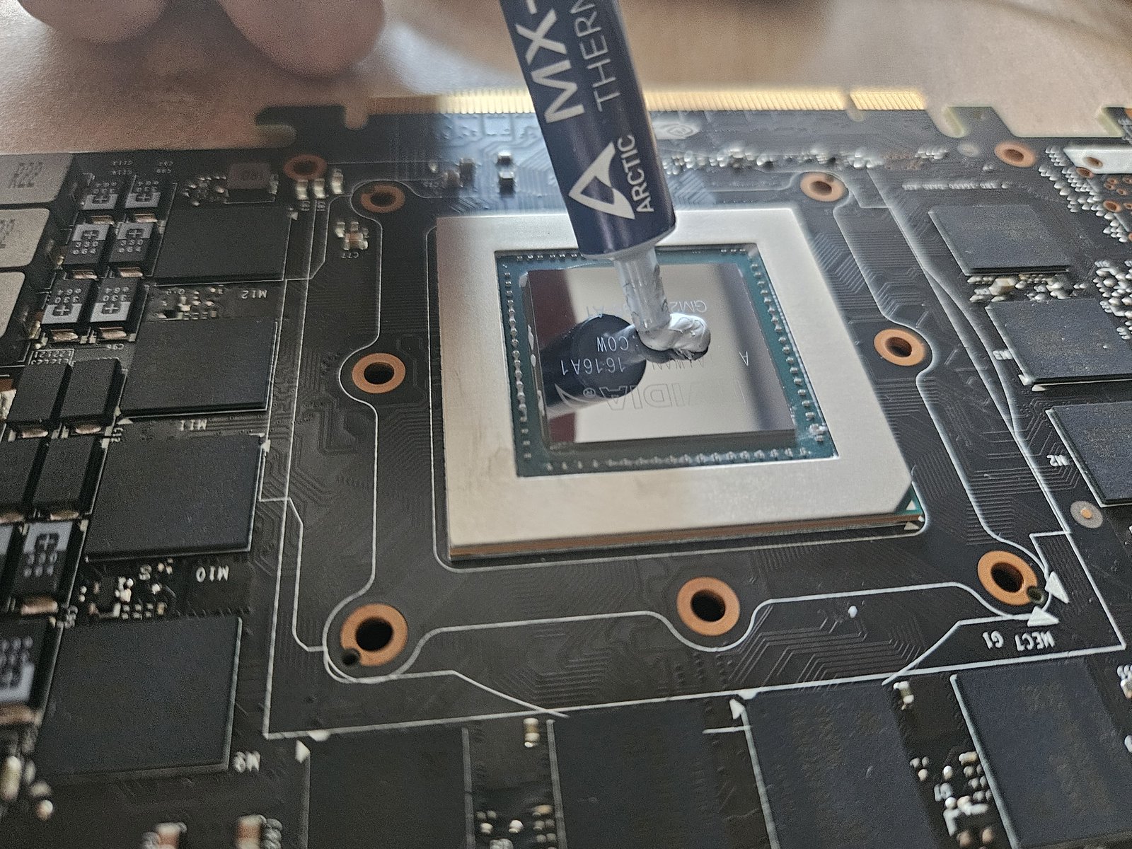 Applying a pea of Arctic MX-4 to the centre of the clean die