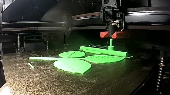 A green part being printed in the workshop