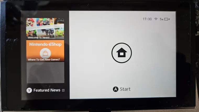 A repaired Nintendo Switch on the Home menu, charging after its USB-C port was replaced