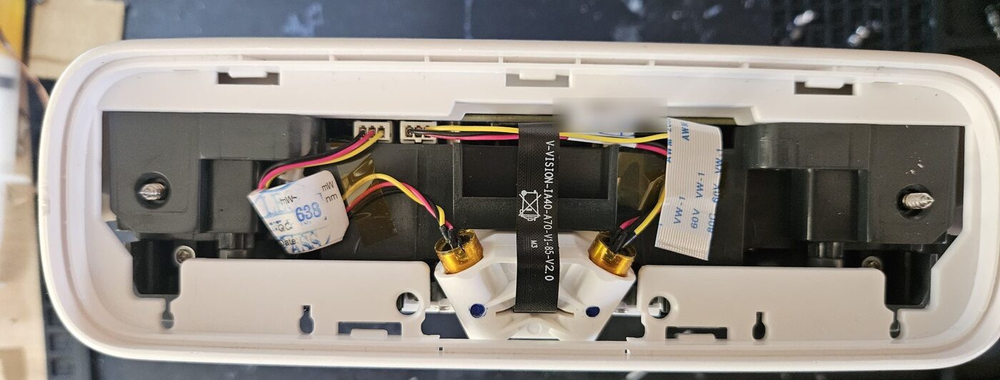 The front of the SkyTrak+ with the front panel removed, showing the white module at the top that holds two lasers with a small camera between them