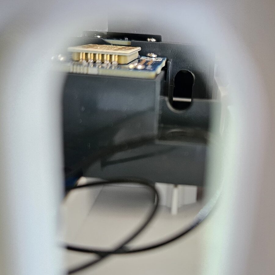 Looking through an opening in the SkyTrak+ chassis at one of the two deep mounting screws