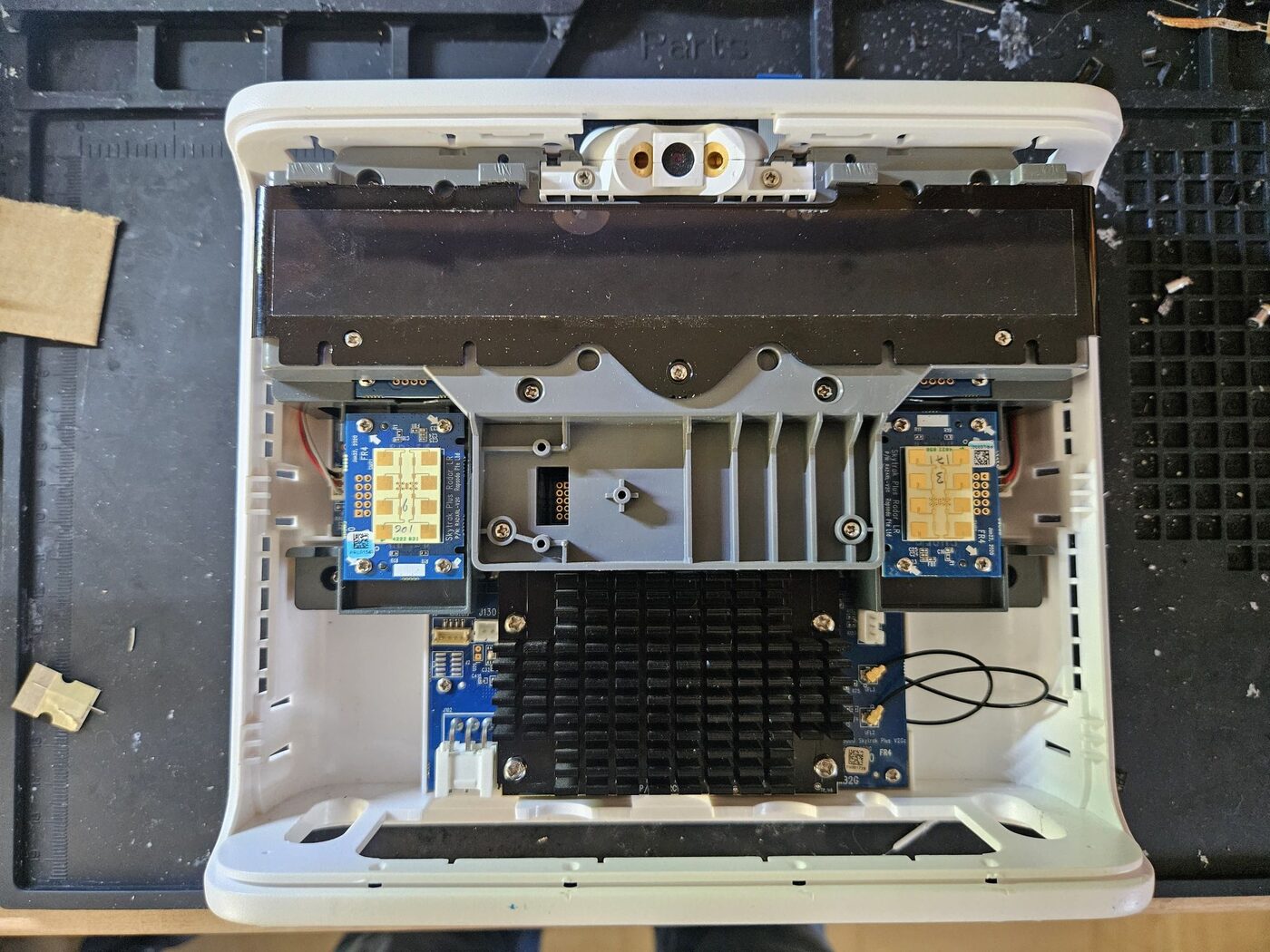 The SkyTrak+ with its top cover removed, showing the main board heatsink, two radar boards and the black camera shield