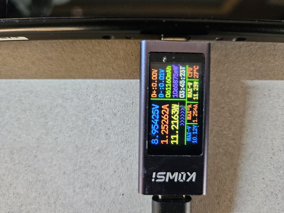 A USB meter plugged into the Switch reading 8.95 volts at 1.25 amps, about 11.2 watts